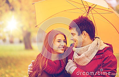 Smiling couple with umbrella in autumn park Stock Photo