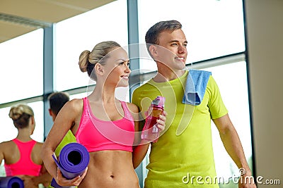 Smiling couple with water bottles in gym Stock Photo
