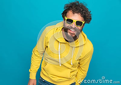 Smiling curly hair guy with yellow hoodie laughing and having fun Stock Photo