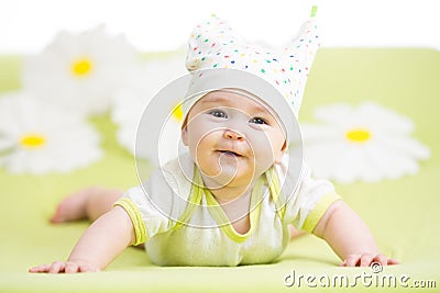 Smiling cute baby lying on green Stock Photo