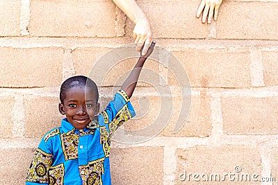 Smiling Cute Black Handsome Boy Standing Outdoors in Front of Wall Stock Photo