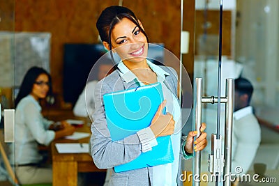 Smiling cute businesswoman standing with folder Stock Photo