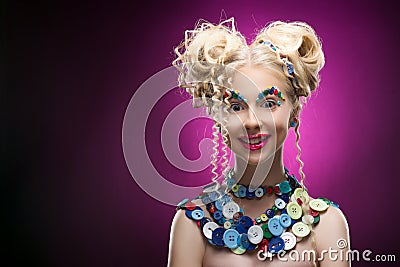 Smiling cute face nice blonde child girl wearing DIY bijou accessories made of multi-colored buttons. Stock Photo