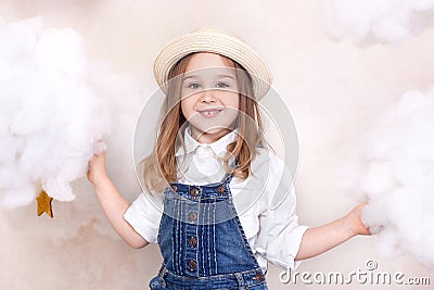 A smiling cute little girl flies in the sky with clouds and stars. Little astrologer Little traveler. The concept of preschool edu Stock Photo