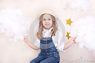 A smiling cute little girl flies in the sky with clouds and stars. Little astrologer Little traveler. The concept of preschool edu Stock Photo