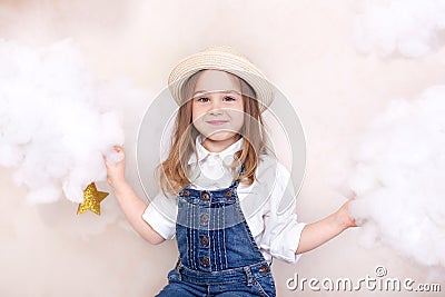 A smiling cute little girl flies in the sky with clouds and stars. Little astrologer Little traveler. The concept of preschool edu Stock Photo