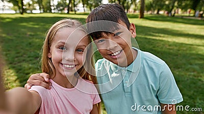 Smiling cute multiracial taking selfie in park Stock Photo