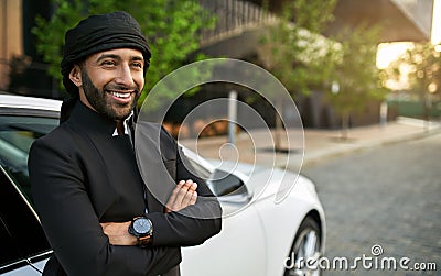 Smiling dapper Arabic Muslim businessman wearing Keffiyeh and arms crossed Stock Photo