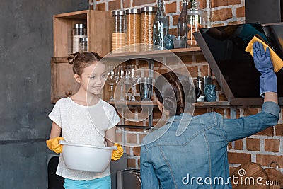 Smiling daughter helping mother with housework at home Stock Photo