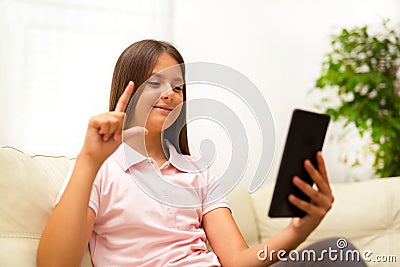 Smiling deaf girl talking using sign language on digital tablet Stock Photo