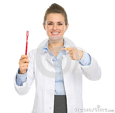 Smiling dental doctor woman pointing toothbrush Stock Photo