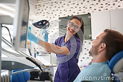 Smiling dentist working with patient in dental clinic Stock Photo