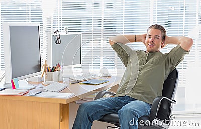Smiling designer leaning back at his desk Stock Photo