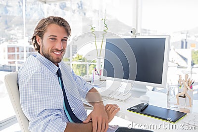 Smiling designer sitting at his desk Stock Photo