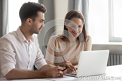 Smiling diverse colleagues work together using laptop Stock Photo