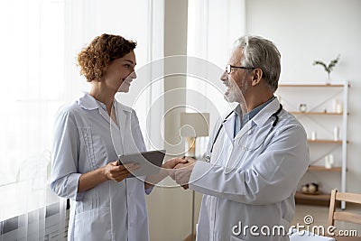 Smiling diverse doctors handshake greeting in hospital Stock Photo