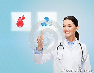 Smiling doctor or nurse pointing to pills icon Stock Photo