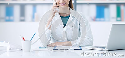Smiling doctor on the phone Stock Photo