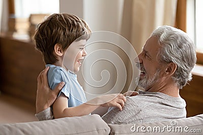 Smiling elderly grandfather playing with small grandson Stock Photo