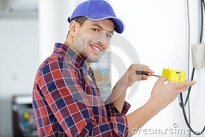 Smiling electrician wiring house Stock Photo