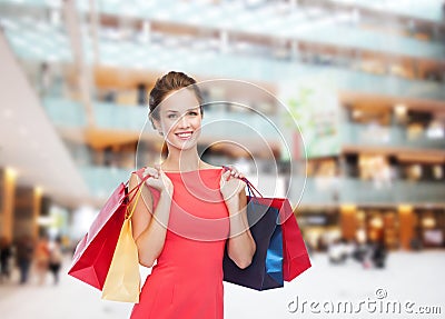 Smiling elegant woman in dress with shopping bags Stock Photo
