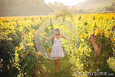 Smiling elegant woman in nature.Joy and happiness.Serene female in wine grape field in sunset.Wine growing field.Agricultural tour Stock Photo