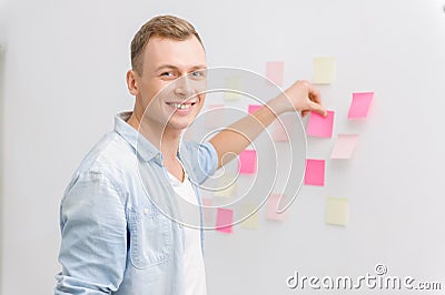 Smiling employee is busy with post-it notes Stock Photo