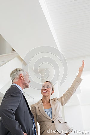 Smiling estate agent showing ceiling to potential buyer Stock Photo