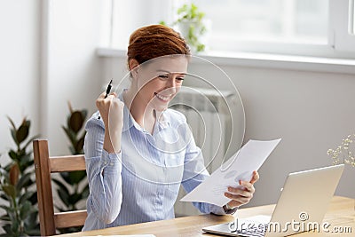 Smiling excited woman feeling happy gesturing yes while reading report Stock Photo