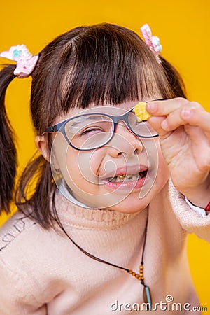 Smiling extraordinary young girl with mental disorder showing wheat flake Stock Photo