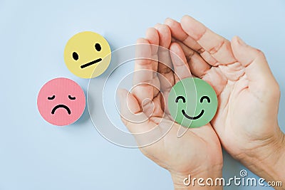 Smiling face in hand on blue background satisfaction survey ,good feedback rating and positive customer review Stock Photo