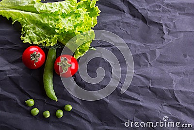 Smiling face from vegetables on black paper background. With space for text Stock Photo