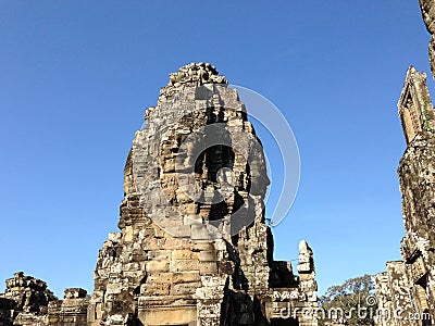 Smiling faces carved into stone walls Stock Photo