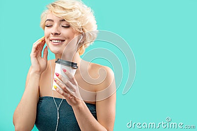 Smiling fair-haired girl is listening to her favourite music Stock Photo