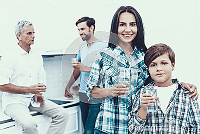 Smiling Family Drinking Water in Glasses at Home. Stock Photo