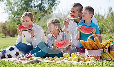 Smiling family of four having picnic and eating watermelon Stock Photo