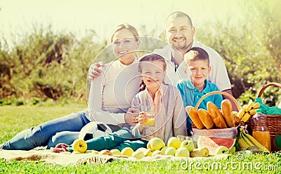 Smiling family of four having a picnic outdoors Stock Photo