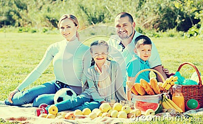 Smiling family of four having a picnic outdoors Stock Photo