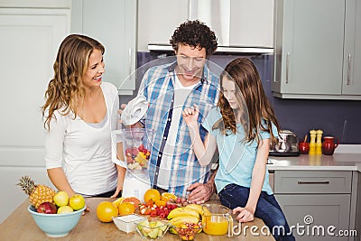 Smiling family preparing fruit juice Stock Photo