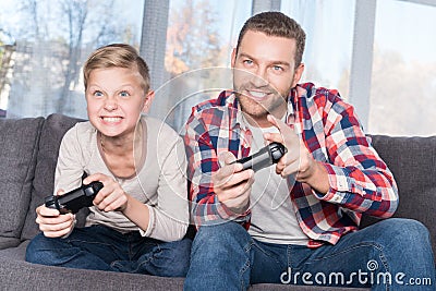 Father and son playing with joysticks Stock Photo