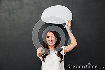 Smiling female asian holding blank speech bubble above her head Stock Photo