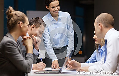 Smiling female boss talking to business team Stock Photo