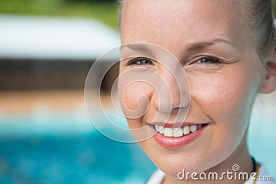Smiling female coach standing near poolside Stock Photo