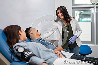 smiling female doctor advising a blood transfusion patient lying Stock Photo