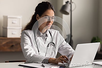 Smiling female doctor work on computer in hospital Stock Photo