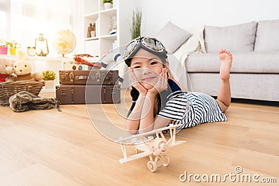 Smiling female kid aviator lying down on floor Stock Photo