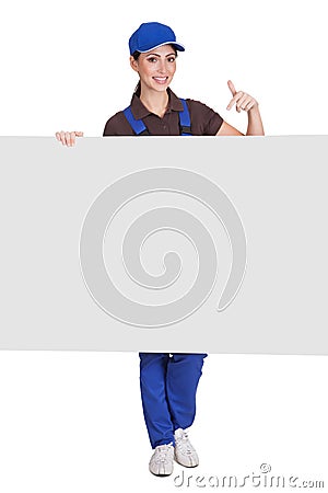 Smiling female plumber holding placard Stock Photo