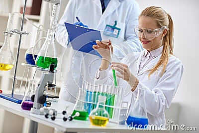 Smiling female scientist using chemistry liquid for research Stock Photo