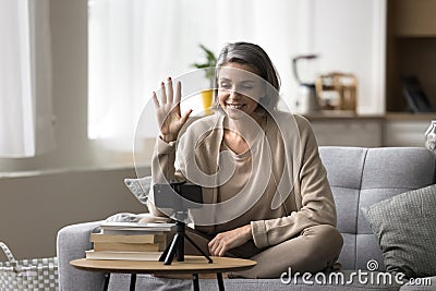 Smiling female vlogger recording videovlog using smartphone camera Stock Photo