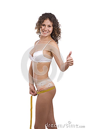 Smiling fit woman with measure tape shows OK Stock Photo